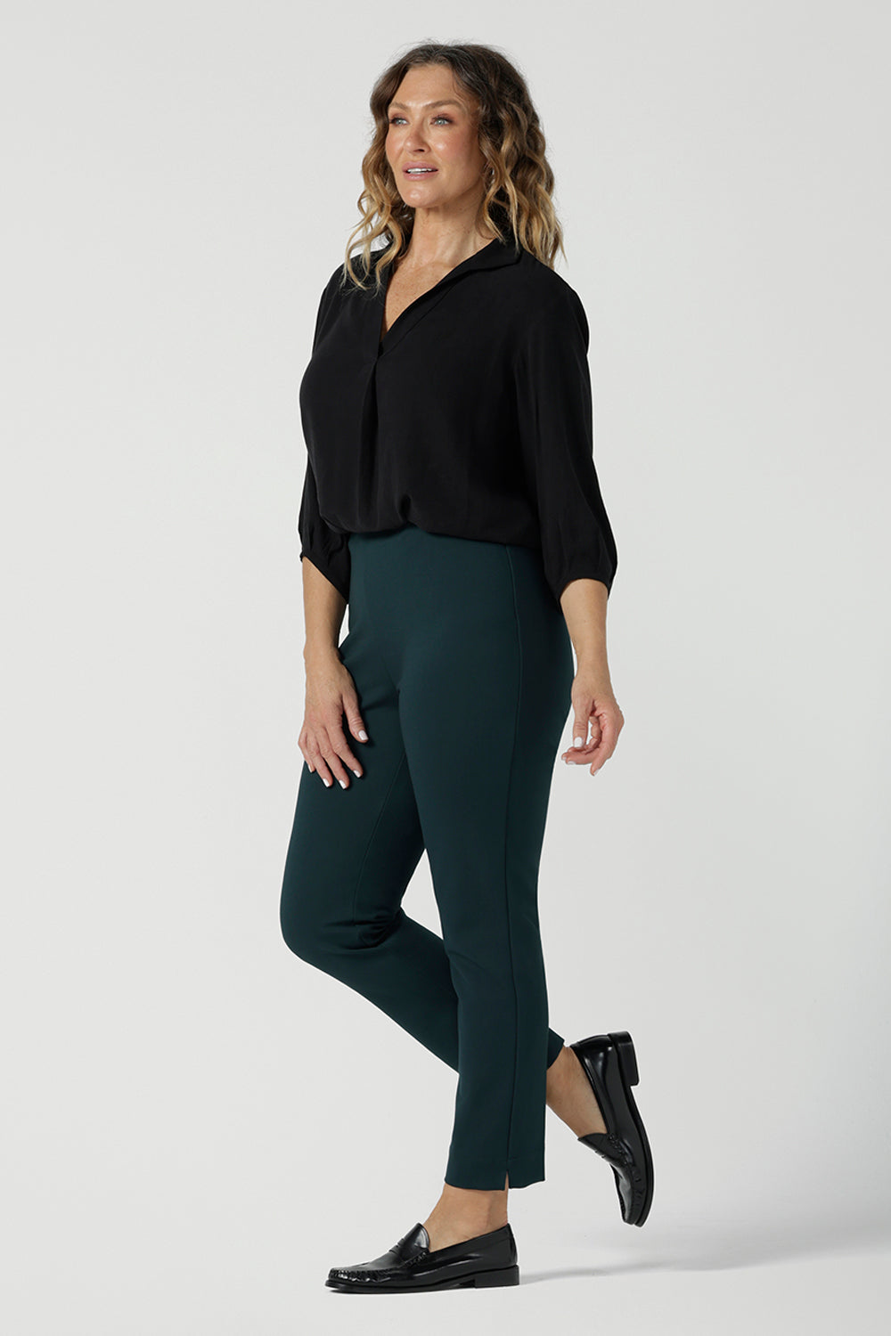 A size 10 woman wears the Paxton Pant for travel wear. Made in Ponte jersey and made in Australia for women size 8-24. Comfortable workwear for women, size inclusive fashion label Leina & Fleur. Styled back with the Ellis Shirt in Black Tencel