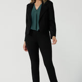 A size 10 woman wears the Paxton Pant in black. A loose fitting ponte pant in black. A slack pant with cropped length. Made in Australia for women size 8-24.