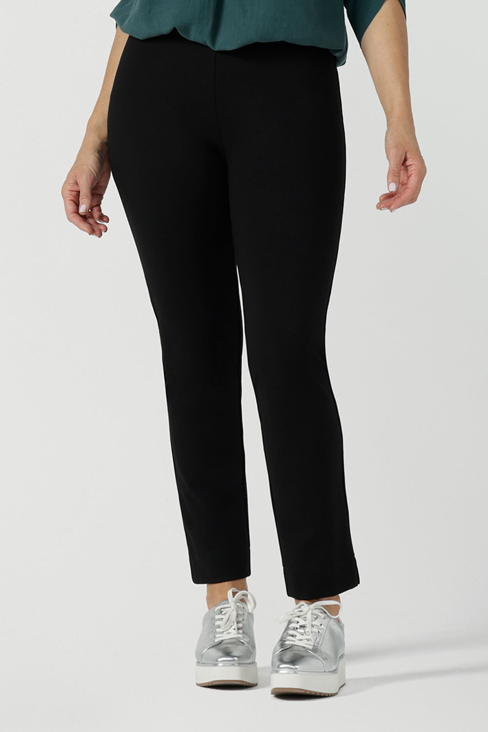 Close up of a size 10 woman wears the Paxton Pant in black. A loose fitting ponte pant in black. A slack pant with cropped length. Made in Australia for women size 8-24. Styled back with the Terry Top in Green.