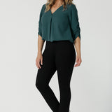 A size 10 woman wears the Paxton Pant in black. A loose fitting ponte pant in black. A slack pant with cropped length. Made in Australia for women size 8-24. Styled back with the Terry Top in  Green. 