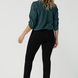 Back view of a size 10 woman wears the Paxton Pant in black. A loose fitting ponte pant in black. A slack pant with cropped length. Made in Australia for women size 8-24. Styled back with the Terry Top in Green.