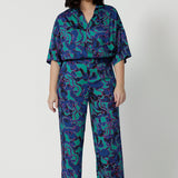 Full front image of a petite woman wearing a lightweight shirt that has above elbow-lengths and an abstract pattern. Made of comfortable satin rayon fabric displaying navy, pink and aqua blue colours. This Australian made house is breathable and made by Australian and New Zealand women. Leina and Fleur is a women’s clothing brand that proudly stocks sizes from 8 to 24 including plus & petite sizes. 