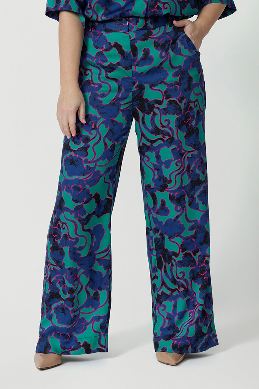 Good pants for petite height women, these wide leg printed pants are part of a coord set. The abstract design of the set displays navy, pink and aqua blue colours. This Australian made shirt and pant set is made from satin rayon fabric that is breathable and comfortable. Leina and Fleur is a women’s clothing company that actively stocks plus sizes & petite sizes ranging from 8 to 24.