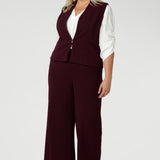 Available in sizes 8-24, this piece is proudly made in Australia by Leina & Fleur, combining both high-quality craftsmanship and contemporary style. Size 18 woman wears tailored vest with wide leg pants and white blouse.