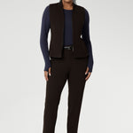 Designed for comfort and versatility, it features a flattering close-to-body fit that moves with you, thanks to its generous stretch and breathable finish. Size 10 woman wears her wool top tucked into her cocoa coloured tapered leg pants, and matching vest.