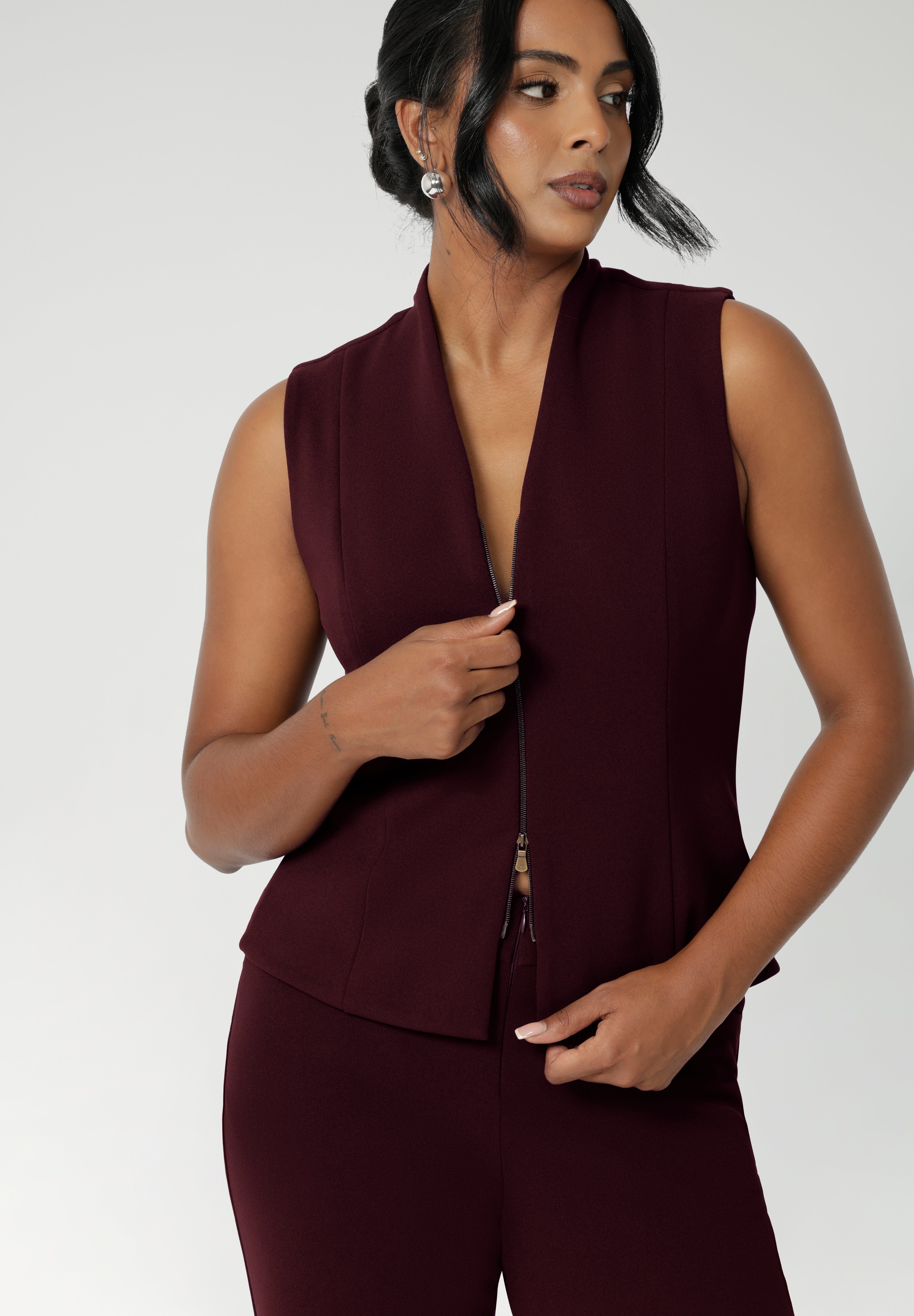 Women's suiting vest features a flattering V-neck and is sleeveless for a modern, sleek look. It’s equipped with a two-way opening zip, offering versatility and ease of movement. Available in sizes 8-24.