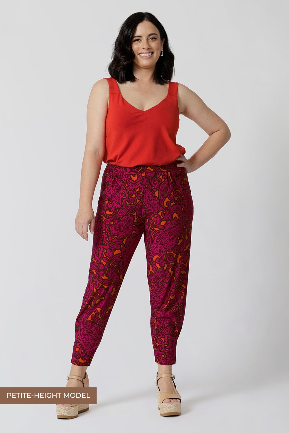 Petite model wears paisley printed travel pants. This pull-on style ensures a relaxed fit, making them effortless to wear for busy days and travel adventures. 