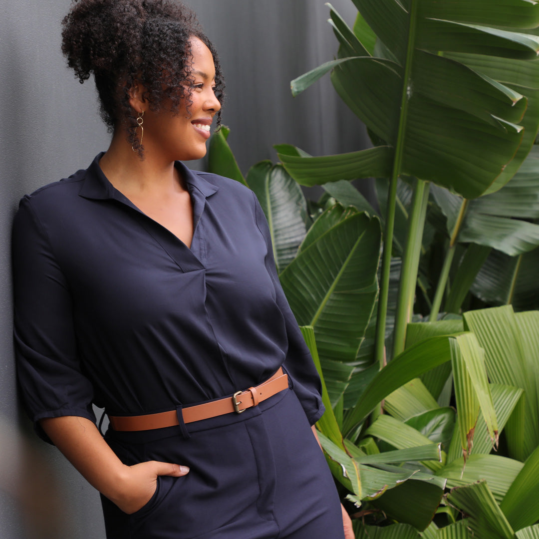 A banner image for a fashion blog on plus size clothing in Australia, a woman wears a plus size sustainable navy shirt and plus size tailored pants in navy.