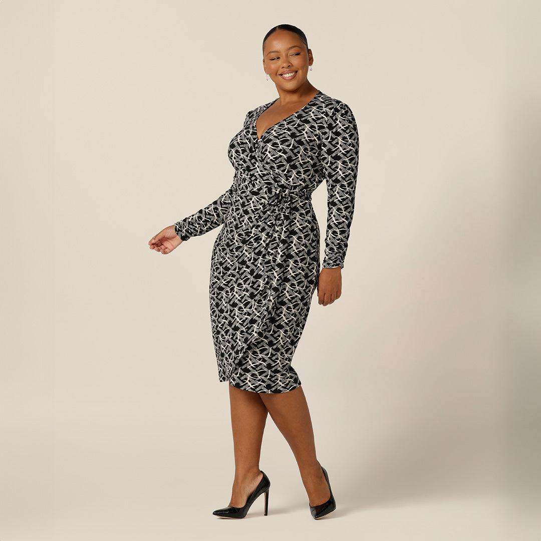 A plus size, size 18 woman wears a long sleeve, curve wrap dress. Made in Australia by women's plus size fashion brand, Leina & Fleur, shop online in sizes 8 to 24. 