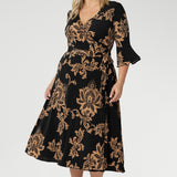 Size 18 woman wears her Portia Dress with black kitten heels. Printed jersey dresses proudly made in Australia and available in sizes 8 to 24. Made with easy care fabric that provides stretch and comfort. 