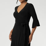 The Portia Dress in Black is the perfect blend of timeless style and modern comfort, designed to flatter every figure. Falling just below the knee, this elegant midi wrap dress features a classic A-line skirt with practical side pockets, offering both form and function.