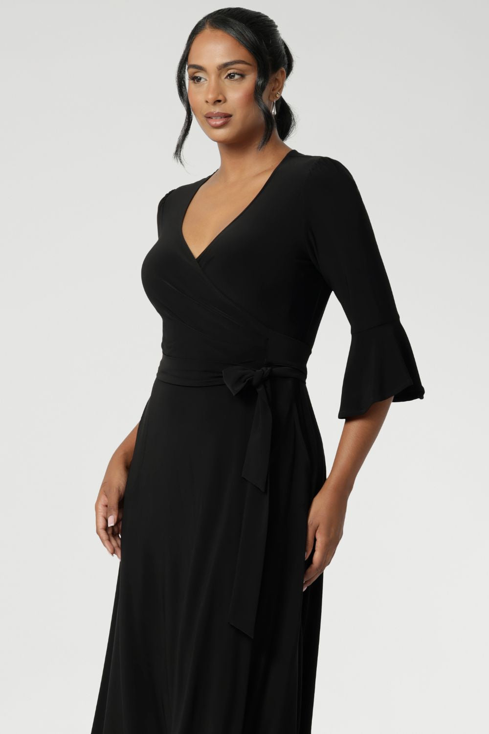 The Portia Dress in Black is the perfect blend of timeless style and modern comfort, designed to flatter every figure. Falling just below the knee, this elegant midi wrap dress features a classic A-line skirt with practical side pockets, offering both form and function.