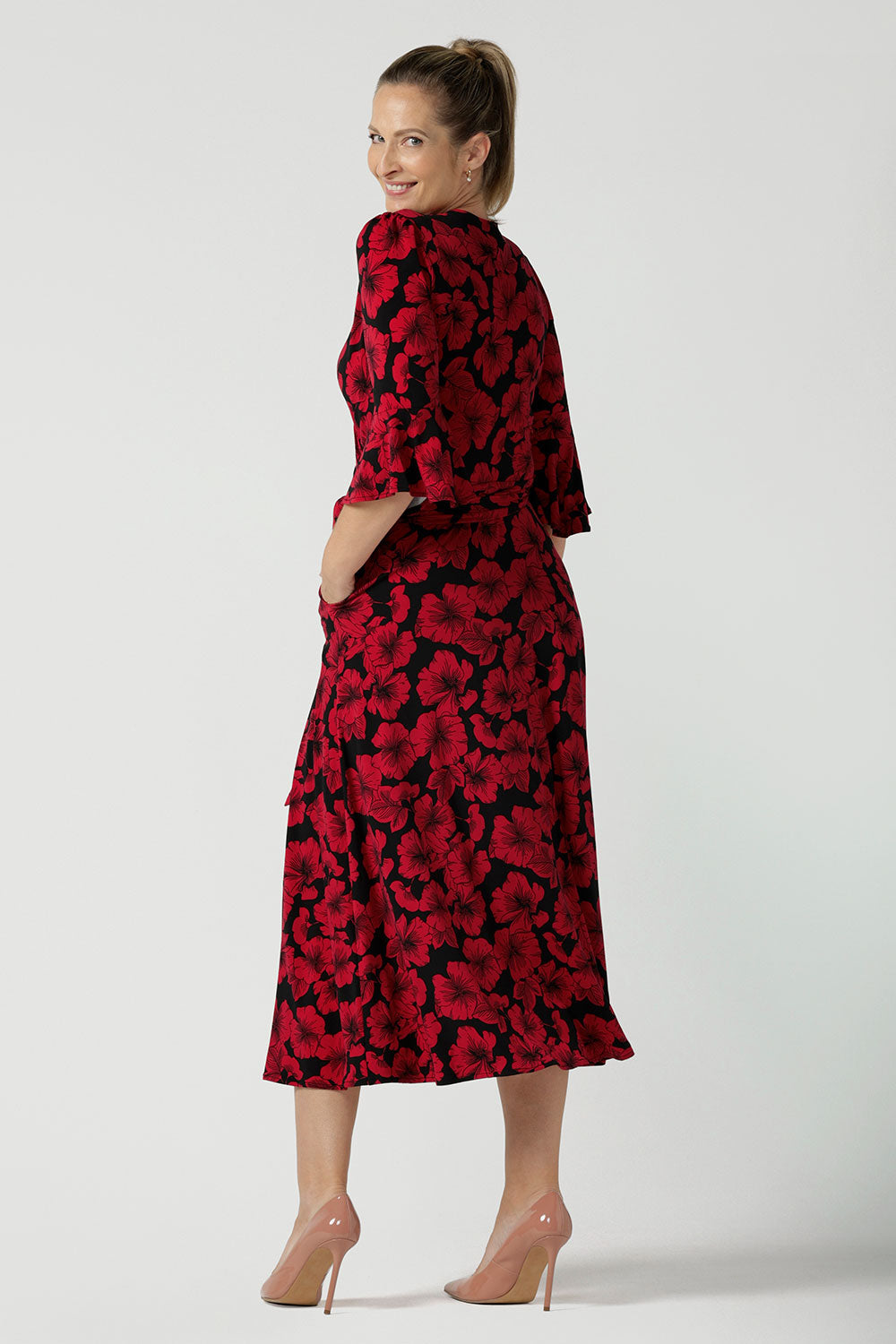 Back view of a size 10 woman wearing the size 10 Portia dress in Bold Poppy. Made in Australia for women size 8 - 24. A functioning wrap dress with waist ties and flutter sleeves.