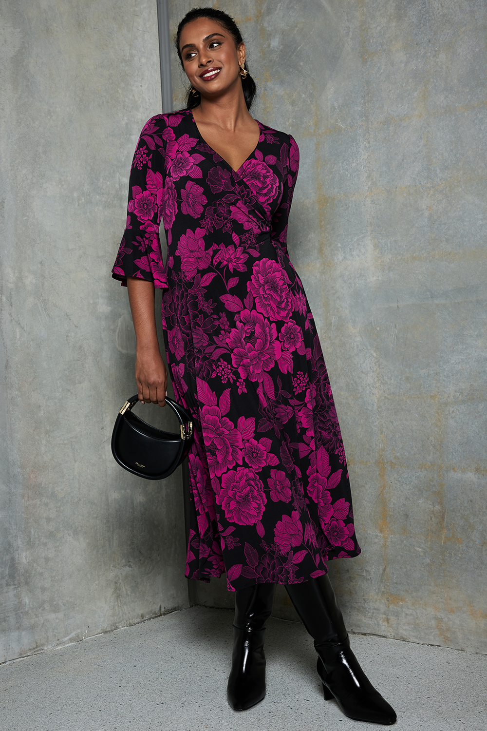 Size 10 woman wears the Portia Wrap dress in Fuchsia Flora. Portia in Fuchsia Flora is a below the knee length wrap dress with pockets. Our signature fluted sleeve detail gives her a romantic feel. Made in Australia for women size 8 - 24. 