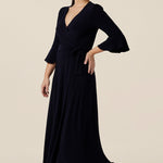 Shown for petite height women, this navy blue wrap dress is perfect for elegant evening and occasion wear. This is a cocktail dress with 3/4 sleeves and a full midi-length skirt. Made in Australia, shop wrap dresses in sizes 8 to 24 at Leina & Fleur.