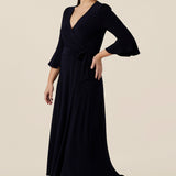 Shown for petite height women, this navy blue wrap dress is perfect for elegant evening and occasion wear. This is a cocktail dress with 3/4 sleeves and a full midi-length skirt. Made in Australia, shop wrap dresses in sizes 8 to 24 at Leina & Fleur.