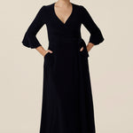 Shown for petite height women, this navy blue wrap dress is perfect for elegant evening and occasion wear. This is a smart casual dress with 3/4, fluted sleeves and a full midi-length skirt. Made in Australia, shop wrap dresses in sizes 8 to 24 at Leina & Fleur.