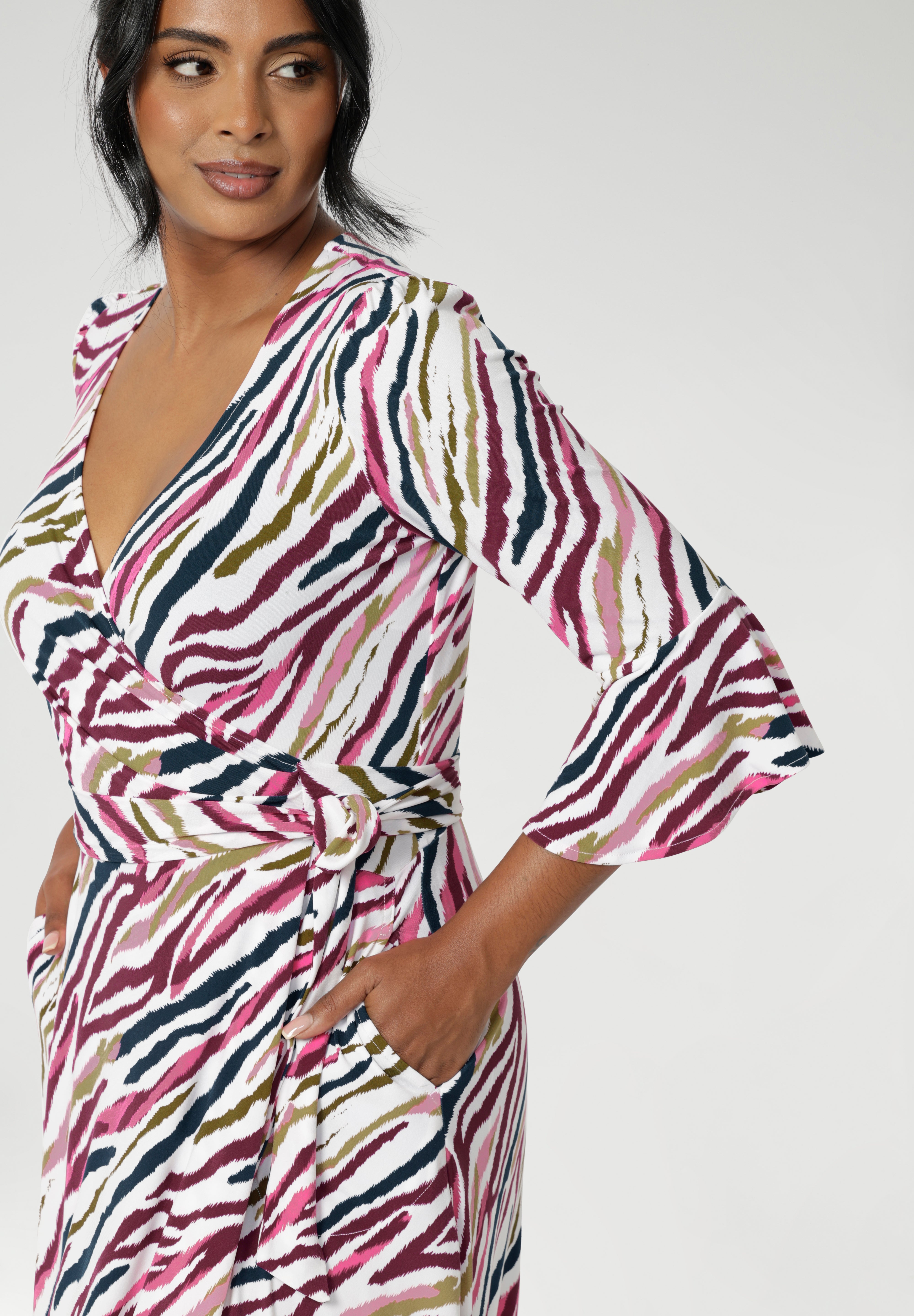 The striking Rainbow Zebra print, featuring shades of pink, taupe, and navy, adds a vibrant and unique touch to the design. Featuring a fluted sleeve design that ads subtle drama. Available in sizes 8-24.