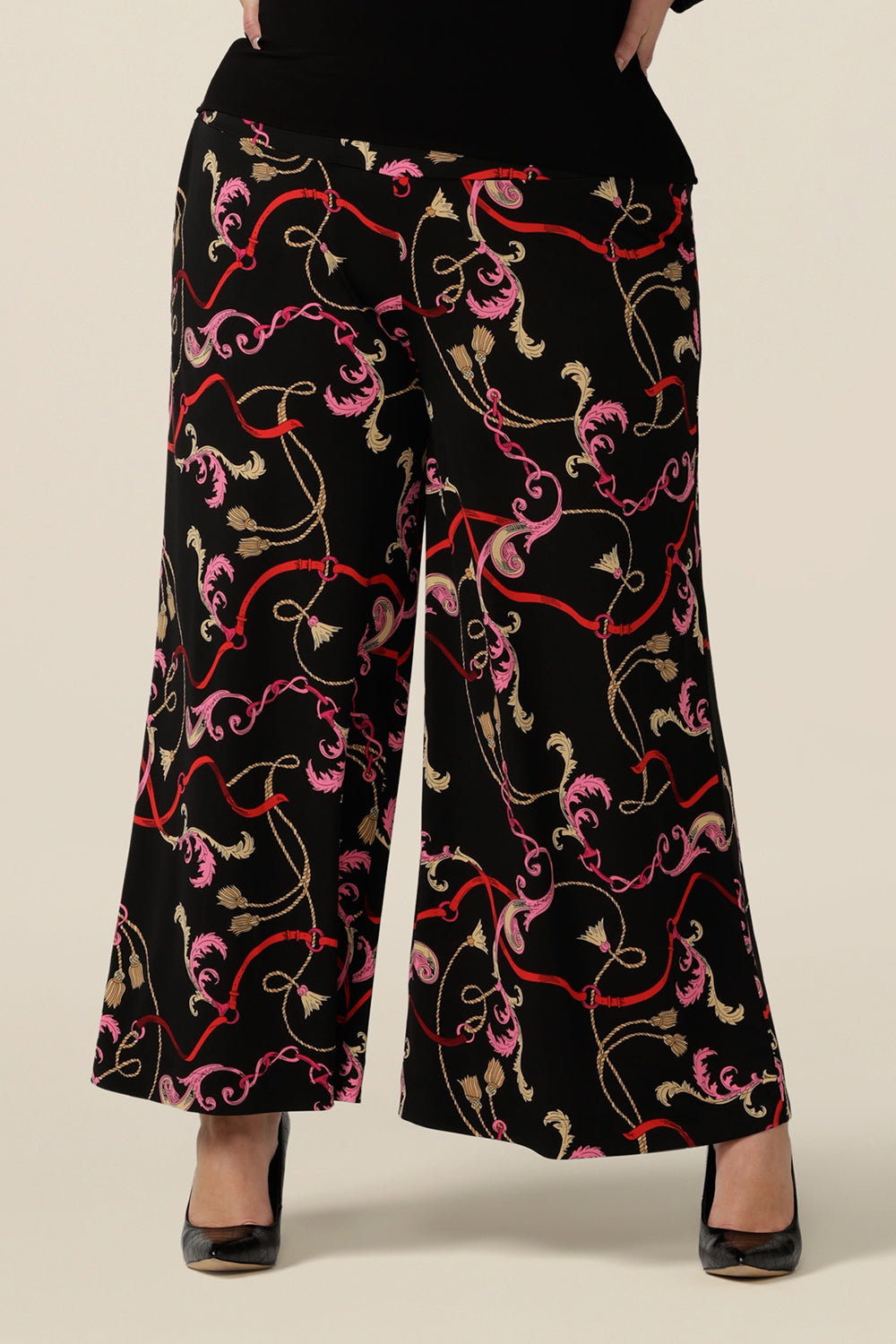A plus size, size 18 woman wears printed wide leg pants with pockets. These pull-on, easy care pants are comfortable for your everyday workwear capsule wardrobe. Shop these Australian-made wide leg trousers online in sizes 8 to 24, petite to plus sizes.