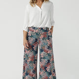 Close up of a size 10 woman wears the Presley Pant in Whimsy, a wide leg pant with a Whimsy print. A made in Australia wide leg pant with a ditsy floral print print. Size inclusive fashion for women size 8-24. Styled back with a Arley Shirt in White Tencel.