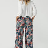 Close up of a size 10 woman wears the Presley Pant in Whimsy, a wide leg pant with a Whimsy print. A made in Australia wide leg pant with a ditsy floral print print. Size inclusive fashion for women size 8-24. Styled back with a Arley Shirt in White Tencel.