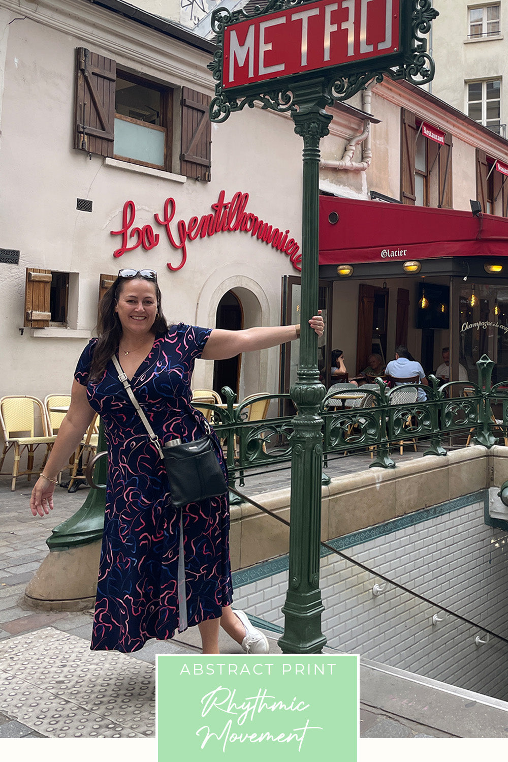 A plus size, curvy woman wears a good wrap dress for travel and holiday wear. With short sleeves, this blue and pink abstract print dress worn for city holidays and sightseeing, is made in Australia by ladies clothes brand, Leina & Fleur.