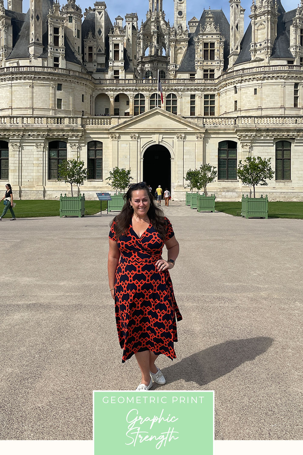 A plus size, curvy woman wears a good wrap dress for travel and holiday wear. With short sleeves, this red and black geometric wrap dress worn for city holidays and sightseeing, is made in Australia by women's clothing brand, Leina & Fleur.