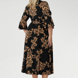 Size 18 woman wears her Portia Dress with black kitten heels. Printed jersey dresses proudly made in Australia and available in sizes 8 to 24. Made with easy care fabric that provides stretch and comfort. 