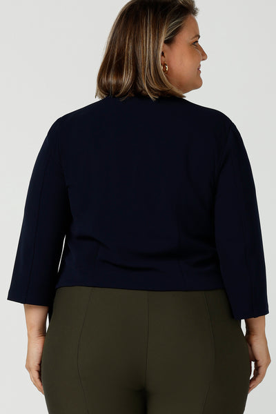 Back view of Australian made open-fronted collarless tailored jacket for stylish corporate women. A soft tailoring jacket in stretch scuba crepe jersey, the Rainy Jacket is collarless and open-fronted with cropped sleeves. Womens size inclusive fashion from petite to plus size 8 - 24.