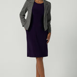 Front view of a size 10 woman wears the Audrey Dress in Amethyst. A purple Jersey dress made for women size 8-24. A comfortable workwear dress for petite to plus size 8-24. Styled back with the Raleigh Jacket in Jacquard made in Australia for women size 8-24.