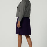 Back view of a size 10 woman wears the Audrey Dress in Amethyst. A purple Jersey dress made for women size 8-24. A comfortable workwear dress for petite to plus size 8-24. Styled back with the Raleigh Jacket in Jacquard made in Australia for women size 8-24.