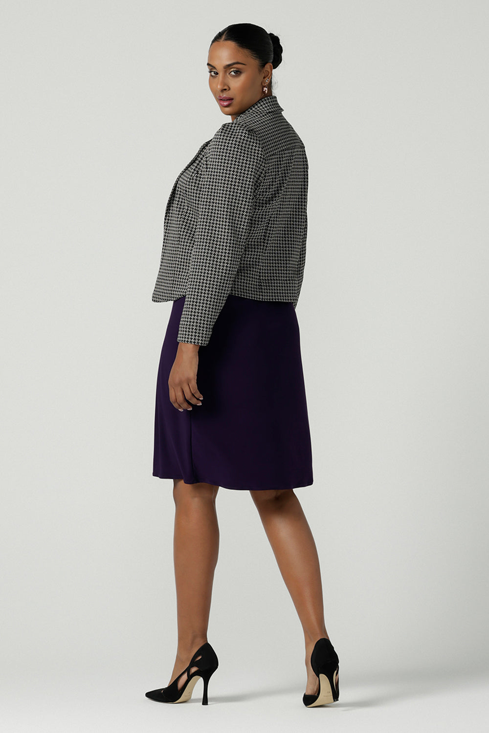 Back view of a size 10 Raleigh Jacket in Jacqaurd has a houndstooth print check with a tailored construction. Comfortable and corporate work wear for women. Petite to plus size clothing for workwear for women size 8-24. Styled back with the Audrey jersey dress in purple amethyst.