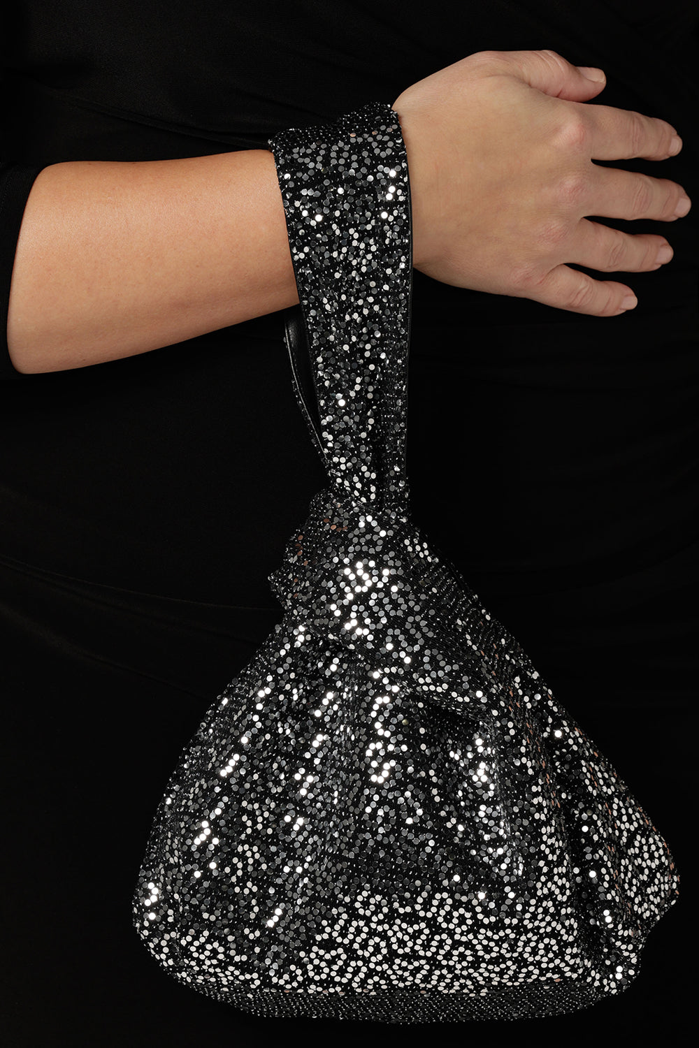 A silver sequin reversible knot bag for evening and event wear. This sparkly evening bag is made in Australia by women's occasionwear brand, Leina & Fleur.