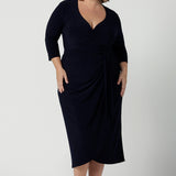 Size 18 curvy woman wears the Robin dress in Navy. Midi length with 3/4 sleeves. V-neckline with a functioning wrap. A great work to weekend piece. Made in Australia for women size 8 - 24.