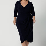 Size 18 curvy woman wears the Robin dress in Navy. Midi length with 3/4 sleeves. V-neckline with a functioning wrap. A great work to weekend piece. Made in Australia for women size 8 - 24.