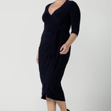 Size 12 woman wears the Robin dress in Navy. Midi length with 3/4 sleeves. V-neckline with a functioning wrap. A great work to weekend piece. Made in Australia for women size 8 - 24.