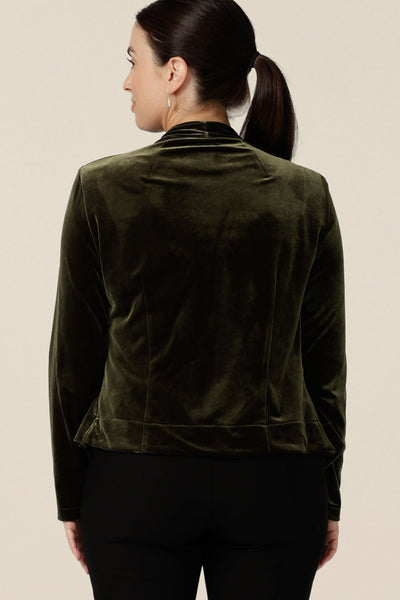 Back view of a size 10, petite height woman wearing a waterfall front velour jacket for evening and cocktail wear. In bracken green this cocktail jacket is good for evening, occasion and wedding guest outfits. Shop made-in-Australian occasionwear in petite to plus sizes at Leina & Fleur.