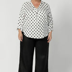 Proudly made in Australia, this pant is available in sizes 8-24, offering an inclusive fit for all women. Black work wear pants are styled with black spotted white blouse and brown small heel. Offering a smart casual office chic look. 