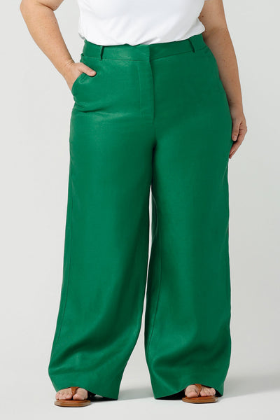 Close up of a size 18 curvy woman wears a tailored linen pant in 100% linen. Breathable linen fabrication in a beautiful emerald green colour. The perfect workwear pants with pockets that make great summer pants. Size inclusive fashion designed and made in Australia size 8 - 24. 