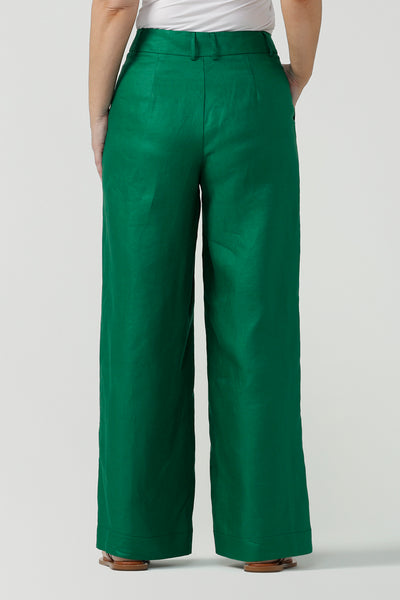 Back view of a size 12 woman wears a tailored linen pant in 100% linen. Breathable linen fabrication in a beautiful emerald green colour. The perfect workwear pants with pockets that make great summer pants. Size inclusive fashion designed and made in Australia size 8 - 24. 
