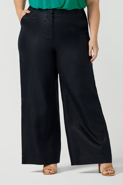 Close up size 18 curvy woman wears a tailored linen pant in 100% linen. Breathable linen fabrication in striking deep midnight navy colour. The perfect workwear pants with pockets that make great summer pants. Size inclusive fashion designed and made in Australia size 8 - 24. 