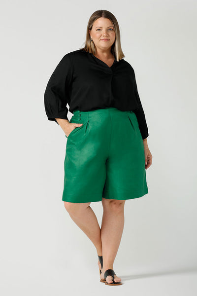 A curvy size 18 woman wears 100% Linen Bermuda shorts. The perfect smart casual shorts suitable for summer workwear to take you through to the weekend. Beautiful emerald green colour and soft tailoring details. Designed and made in Australia for sizes 8 -24.
