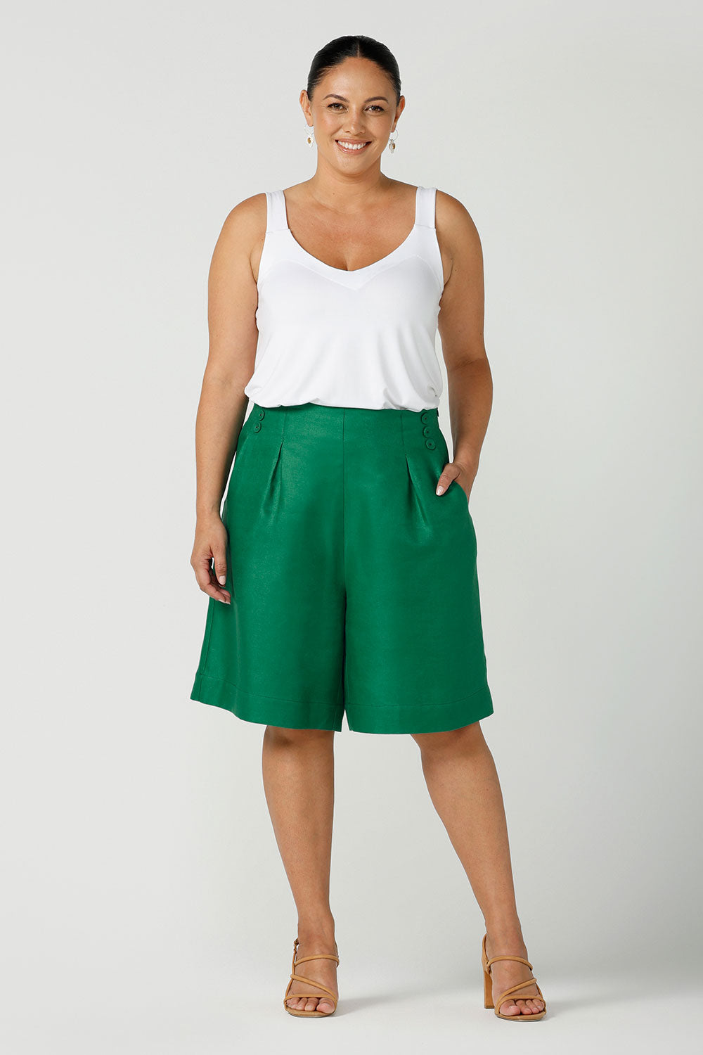 A size 12 woman wears 100% Linen Bermuda shorts. The perfect smart casual shorts suitable for summer workwear to take you through to the weekend. Beautiful emerald green colour and soft tailoring details. Designed and made in Australia for sizes 8 -24.