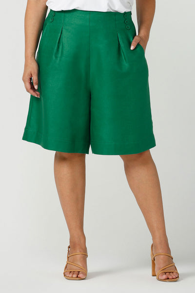 Close up of a size 12 woman wears 100% Linen Bermuda shorts. The perfect smart casual shorts suitable for summer workwear to take you through to the weekend. Beautiful emerald green colour and soft tailoring details. Designed and made in Australia for sizes 8 -24.