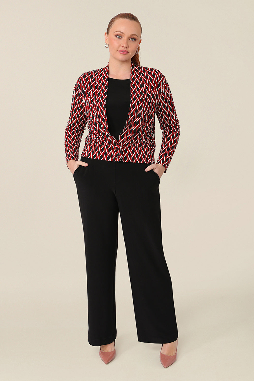 A curvy woman wears a soft jacket/cardigan with long sleeves and covered button fastenings, with a black top and wide leg black work pants. An easy throw on jacket for work, office and casual wear, shop made-in-Australia workwear petite to plus sizes