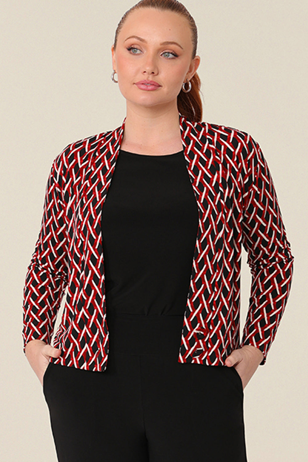 A curvy woman wears a soft jacket/cardigan with long sleeves and covered button fastenings, styled open over a black top . An easy throw on jacket for work, office and casual wear, shop made-in-Australia workwear petite to plus sizes