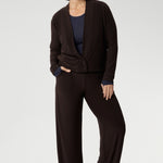 Mature aged woman wears the Sandro Jacardi in Cocoa which is a jacket-like cardigan that effortlessly adds layered dresses, making it an essential piece in our Fluid Suiting collection. Crafted from a heavyweight dry-touch jersey fabric with a soft stretch, this cardigan offers both comfort and structure.