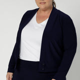 Size 18 curvy woman wears a jersey jacket/cardigan style in navy. With long sleeves, this jacket-cardigan hybrid is cool weather cover up for women. Easily transition into cooler months in style, with this comfortable jacket for workwear and casual layering. Available in sizes 8-24.