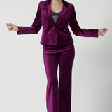 Front view of a size 10 woman wears the Sasha jacket in Magenta velveteen. A cocktail pant suit that is made in Australia for size 8 - 24. A matching suit set in velveteen. Event wear for petite to plus size women. Styled back with the Jonas pant.