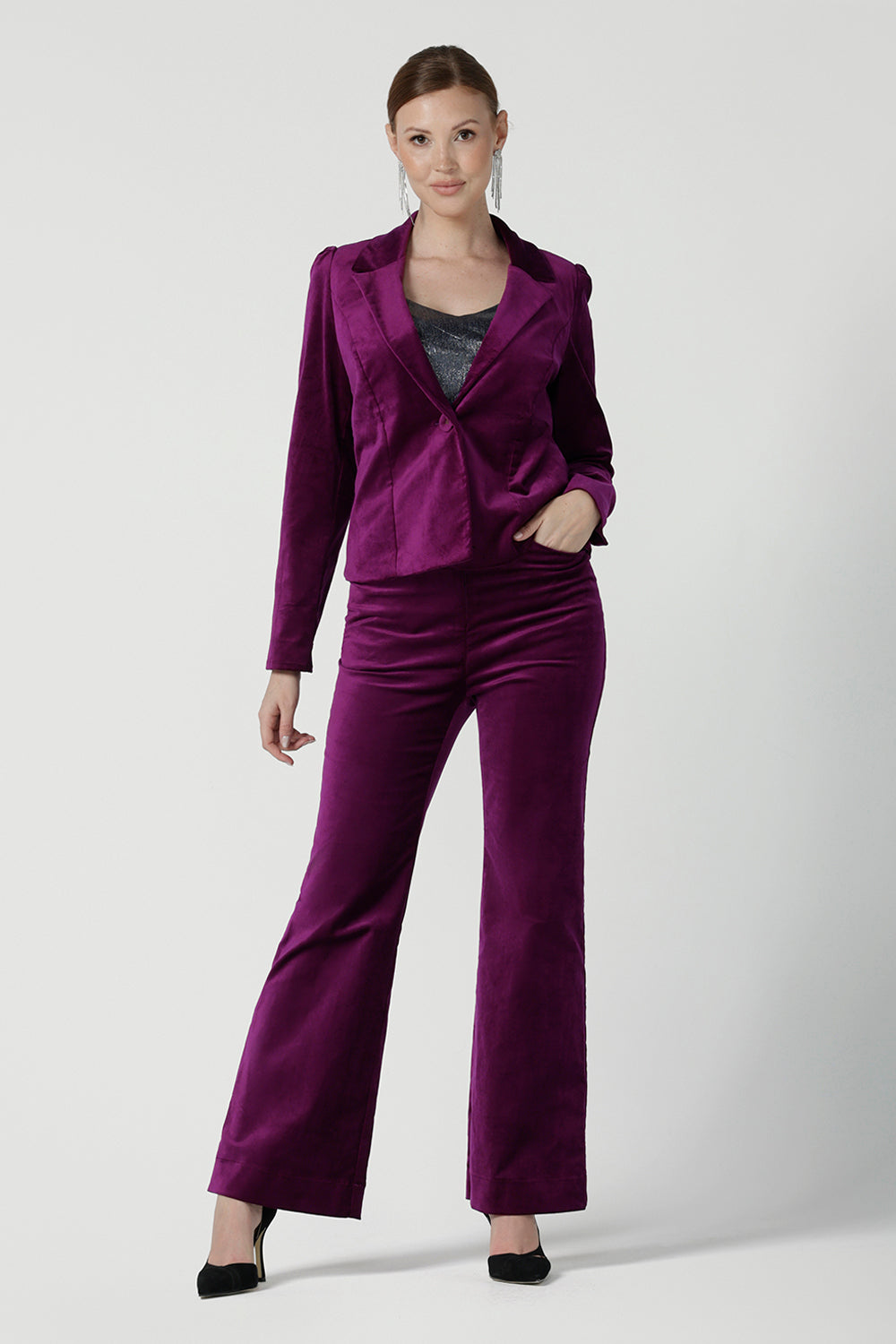 Front view of a size 10 woman wears the Sasha jacket in Magenta velveteen. A cocktail pant suit that is made in Australia for size 8 - 24. A matching suit set in velveteen. Event wear for petite to plus size women. Styled back with the Jonas pant.